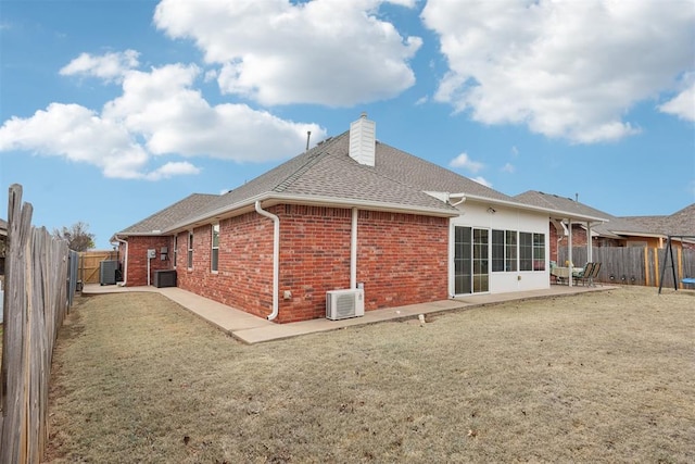 rear view of property with a patio area, a fenced backyard, brick siding, and a chimney