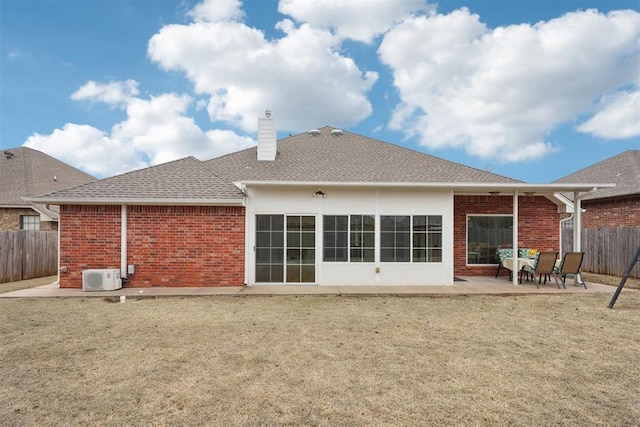 rear view of house featuring brick siding, fence, roof with shingles, a chimney, and a patio area