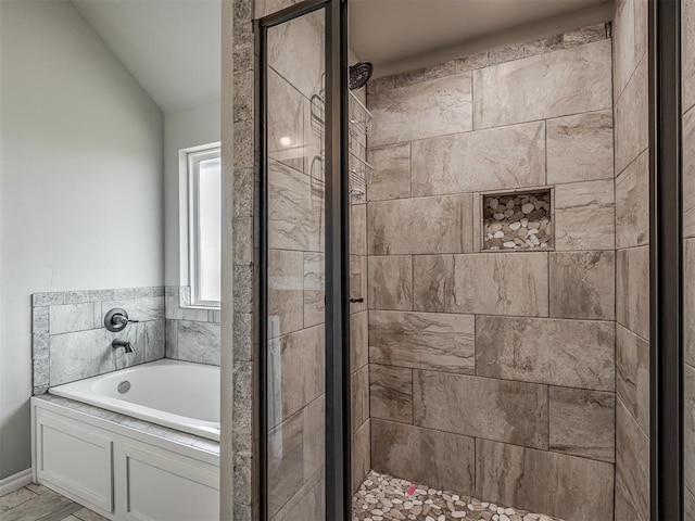 bathroom with a shower stall, a garden tub, and lofted ceiling