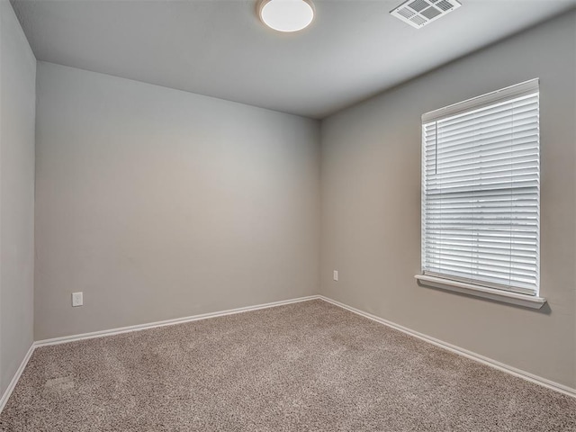 carpeted empty room with visible vents and baseboards