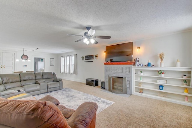 carpeted living area featuring baseboards, a brick fireplace, a textured ceiling, and ceiling fan