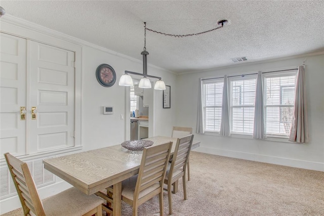 dining area featuring baseboards, visible vents, ornamental molding, a textured ceiling, and light colored carpet