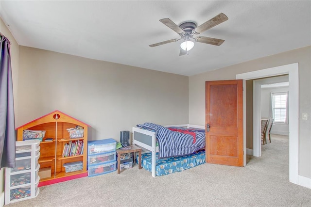 carpeted bedroom with baseboards and a ceiling fan