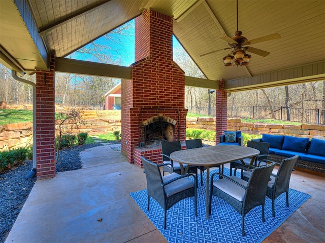 view of patio / terrace featuring ceiling fan, an outdoor living space with a fireplace, outdoor dining space, and fence