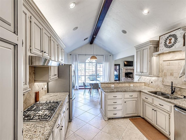 kitchen with under cabinet range hood, lofted ceiling with beams, a peninsula, stainless steel appliances, and a sink