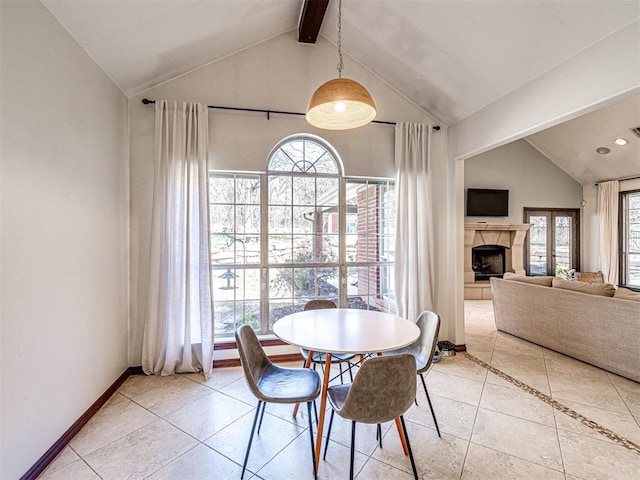 dining area with a healthy amount of sunlight, lofted ceiling with beams, and baseboards