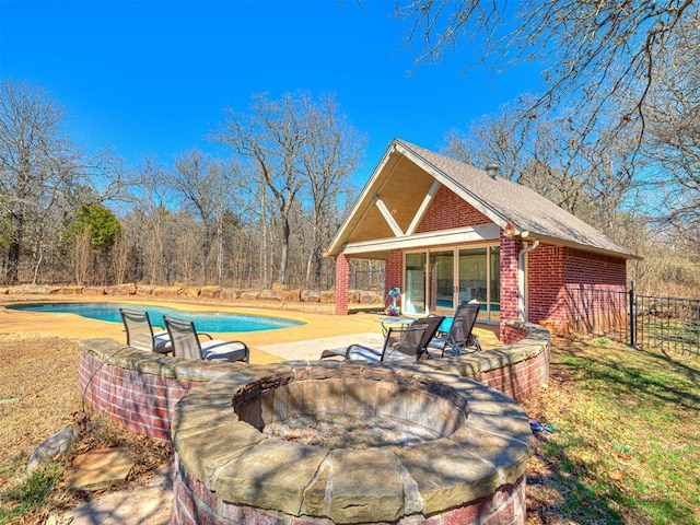 view of patio / terrace with a fenced in pool, an exterior structure, fence, an outdoor fire pit, and an outdoor structure