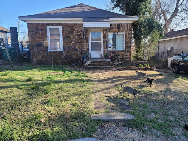 1626 NW 12th St, Oklahoma City, OK 73106 - view of front of home with stone siding, a shingled roof, and a front yard