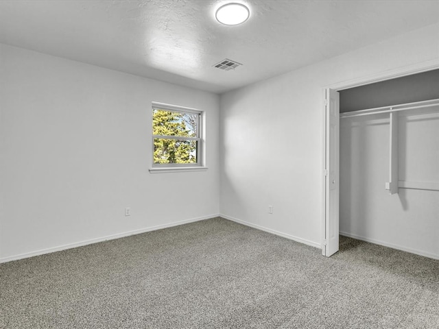 unfurnished bedroom with a closet, baseboards, visible vents, and carpet floors