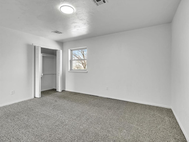 unfurnished bedroom featuring a closet, visible vents, baseboards, and carpet floors