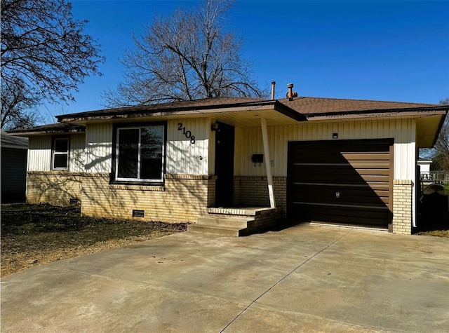 view of front of house with brick siding, a shingled roof, concrete driveway, crawl space, and an attached garage