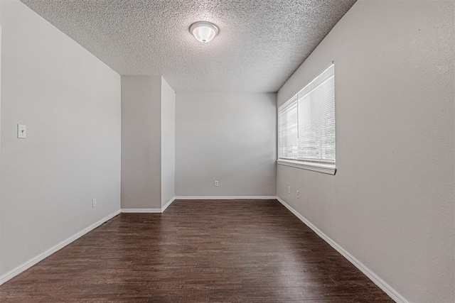 spare room with baseboards, a textured ceiling, and wood finished floors