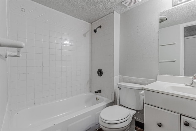 full bathroom featuring visible vents, toilet, shower / bathtub combination, a textured ceiling, and vanity