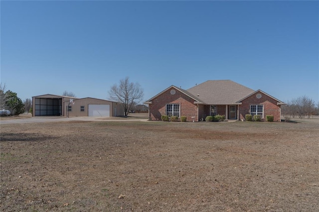 view of front of property featuring a garage, an outbuilding, and brick siding