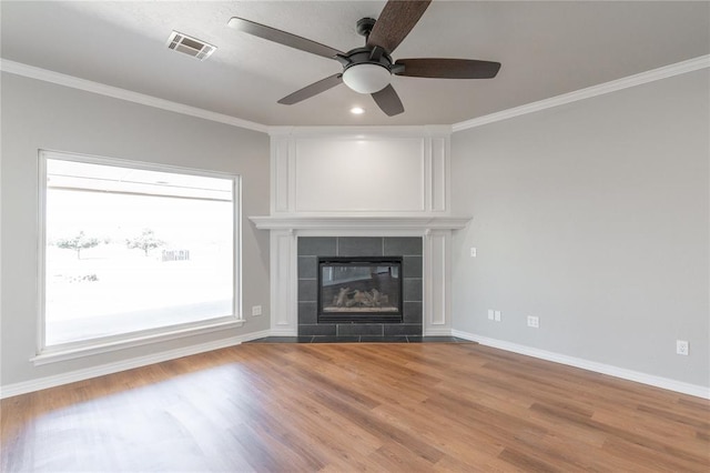 unfurnished living room featuring visible vents, baseboards, crown molding, and a tile fireplace