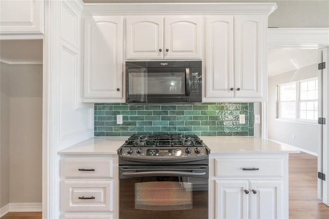 kitchen with backsplash, white cabinetry, black appliances, and light countertops