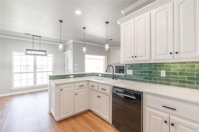 kitchen featuring a peninsula, ornamental molding, decorative backsplash, a sink, and black dishwasher