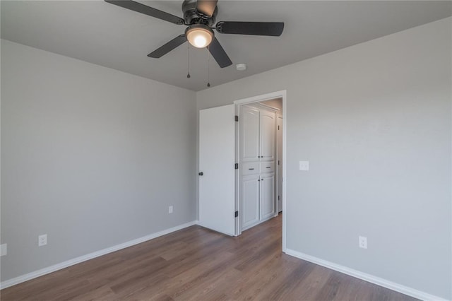 unfurnished room with ceiling fan, baseboards, and wood finished floors