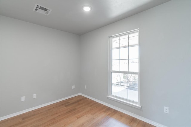 spare room with visible vents, baseboards, and light wood finished floors