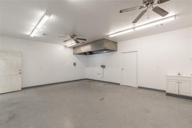 garage with visible vents, baseboards, and a ceiling fan