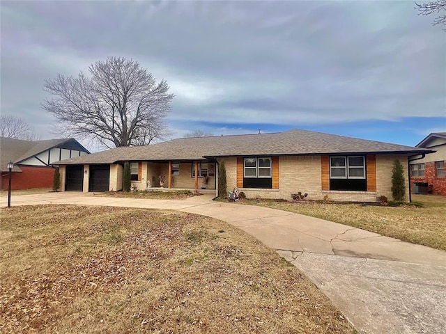 ranch-style house with brick siding, a shingled roof, a front lawn, concrete driveway, and a garage