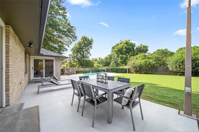 view of patio with outdoor dining area, a fenced in pool, and a fenced backyard