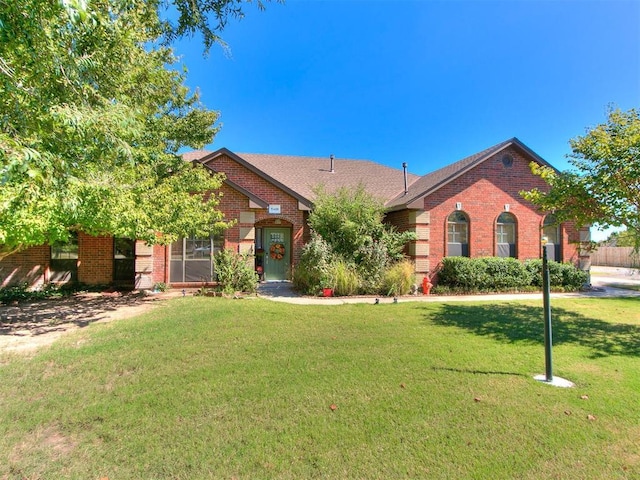 view of front of property with brick siding and a front lawn