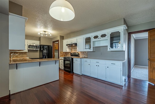 kitchen featuring black appliances, under cabinet range hood, tasteful backsplash, a peninsula, and dark wood-style flooring