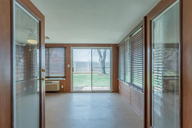 unfurnished sunroom featuring a wall mounted AC