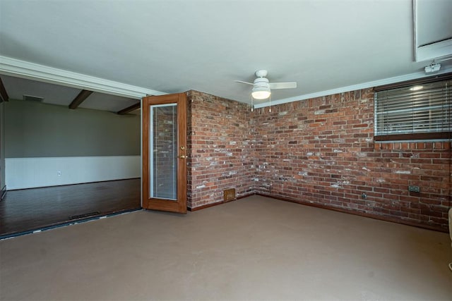 empty room with visible vents, a wainscoted wall, brick wall, and a ceiling fan