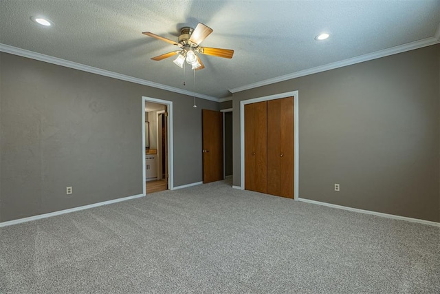 unfurnished bedroom with carpet flooring, a textured ceiling, crown molding, and baseboards