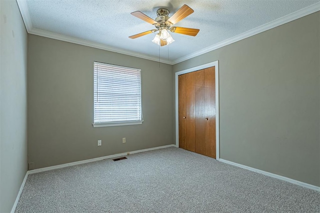 unfurnished bedroom with visible vents, a textured ceiling, crown molding, and carpet