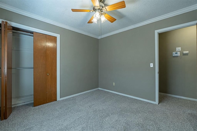 unfurnished bedroom featuring baseboards, carpet floors, ornamental molding, a closet, and a textured ceiling