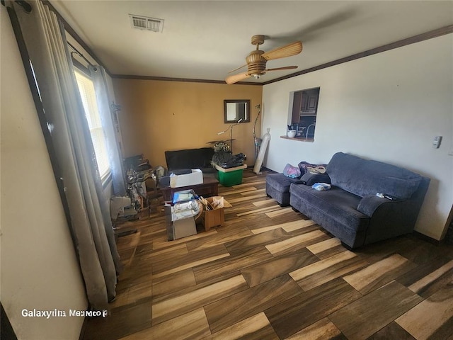 living room featuring visible vents, crown molding, a ceiling fan, and wood finished floors