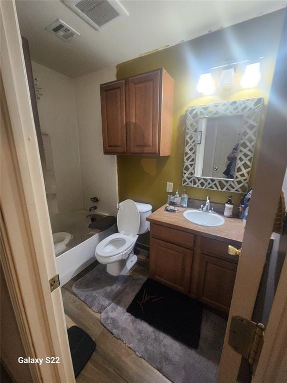 full bathroom with visible vents, toilet, wood finished floors, and vanity