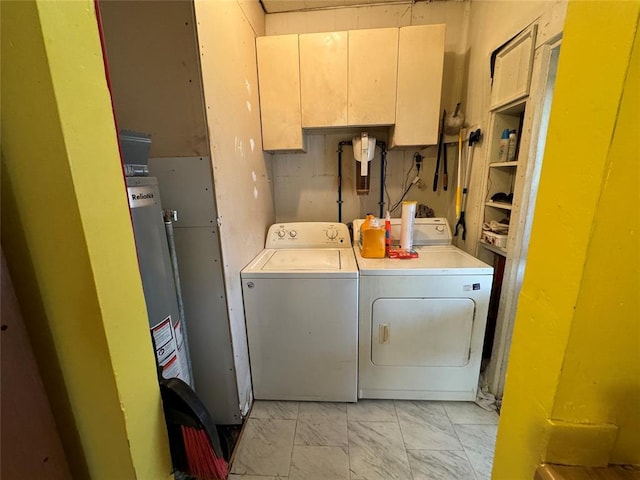 washroom featuring laundry area, marble finish floor, gas water heater, and washing machine and clothes dryer
