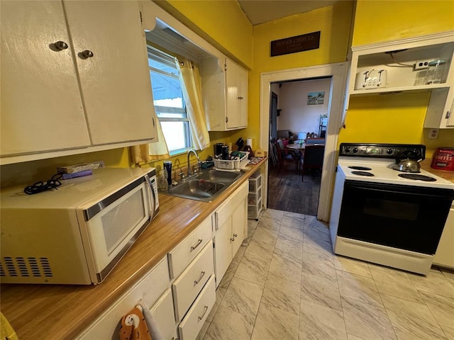 kitchen with white microwave, light countertops, white cabinetry, a sink, and range with electric cooktop