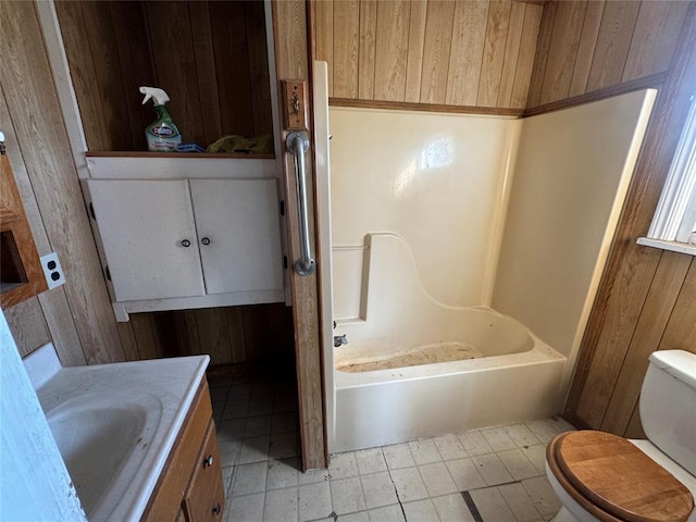 bathroom with vanity, wood walls, and toilet
