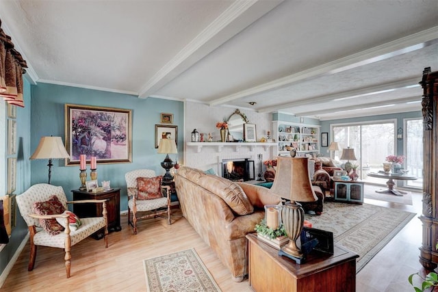 living room with beam ceiling, a warm lit fireplace, wood finished floors, and crown molding