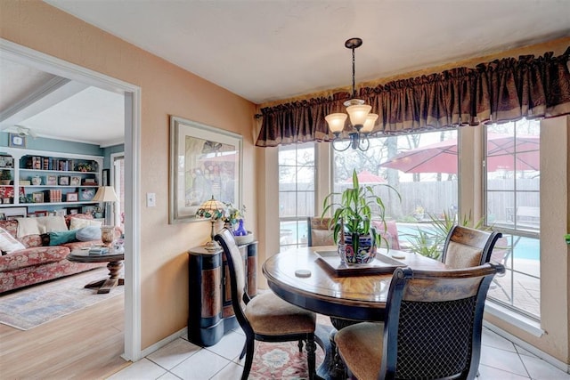 dining space with light tile patterned floors, a notable chandelier, and baseboards