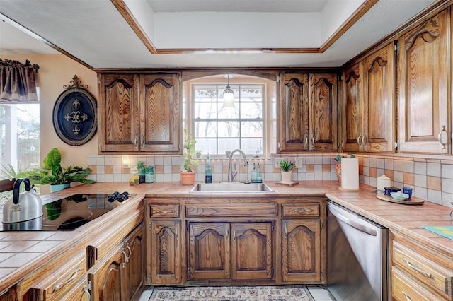 kitchen with dishwasher, tile counters, and a sink