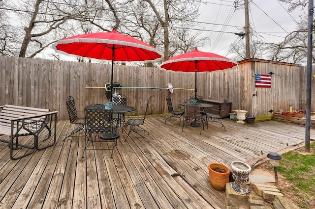 wooden terrace with outdoor dining space and fence