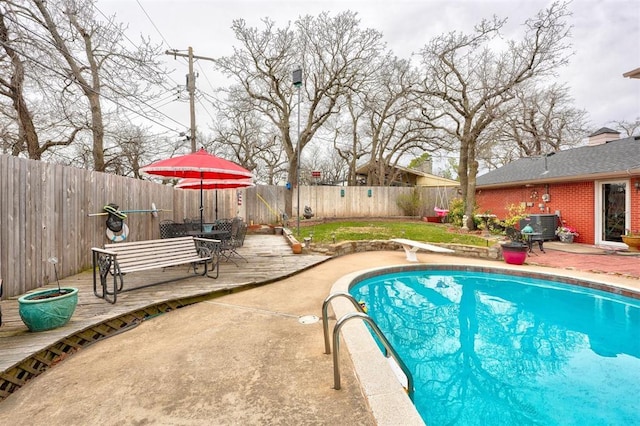 view of pool featuring a patio, a fenced in pool, a fenced backyard, a diving board, and a deck