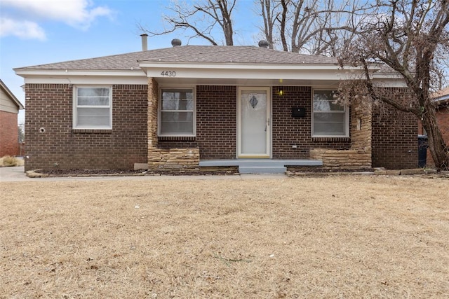 view of front of property featuring a front yard and brick siding