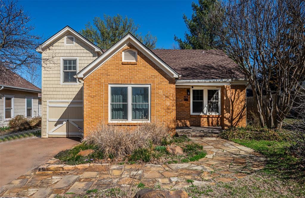 view of front of home featuring brick siding and driveway