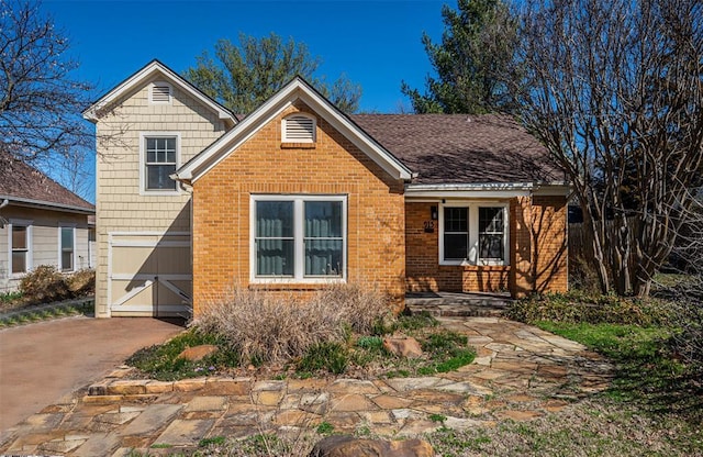 view of front of home featuring brick siding and driveway