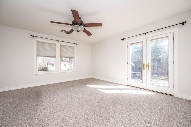 carpeted empty room featuring french doors, visible vents, a wealth of natural light, and baseboards