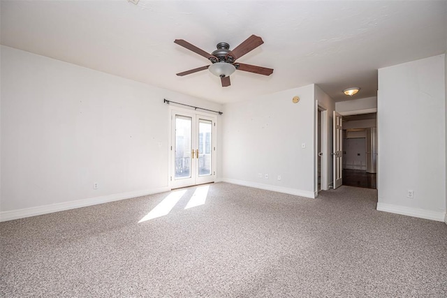 carpeted spare room with french doors, a ceiling fan, and baseboards