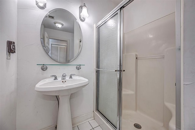 bathroom featuring tile patterned floors and a shower stall