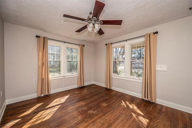 spare room with ceiling fan, baseboards, wood-type flooring, and a textured ceiling